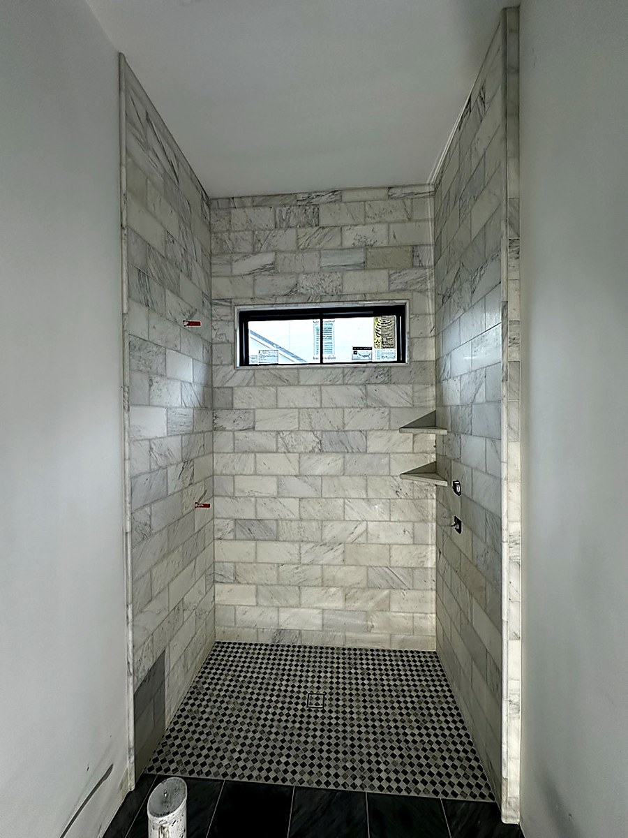 Marble subway shower with mosaic floor by KV Tileworks, Central Florida