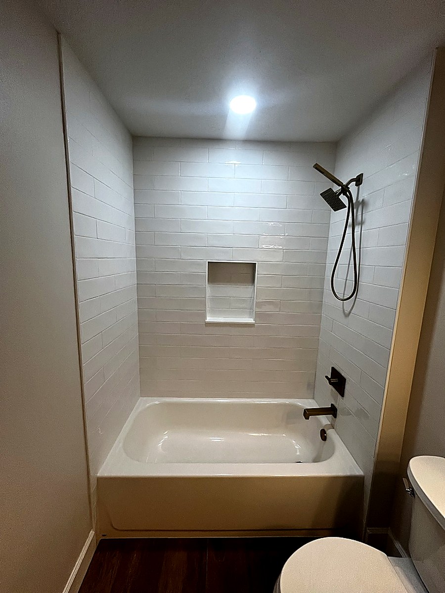White subway tub surround with brass fixtures by KV Tileworks, Central Florida