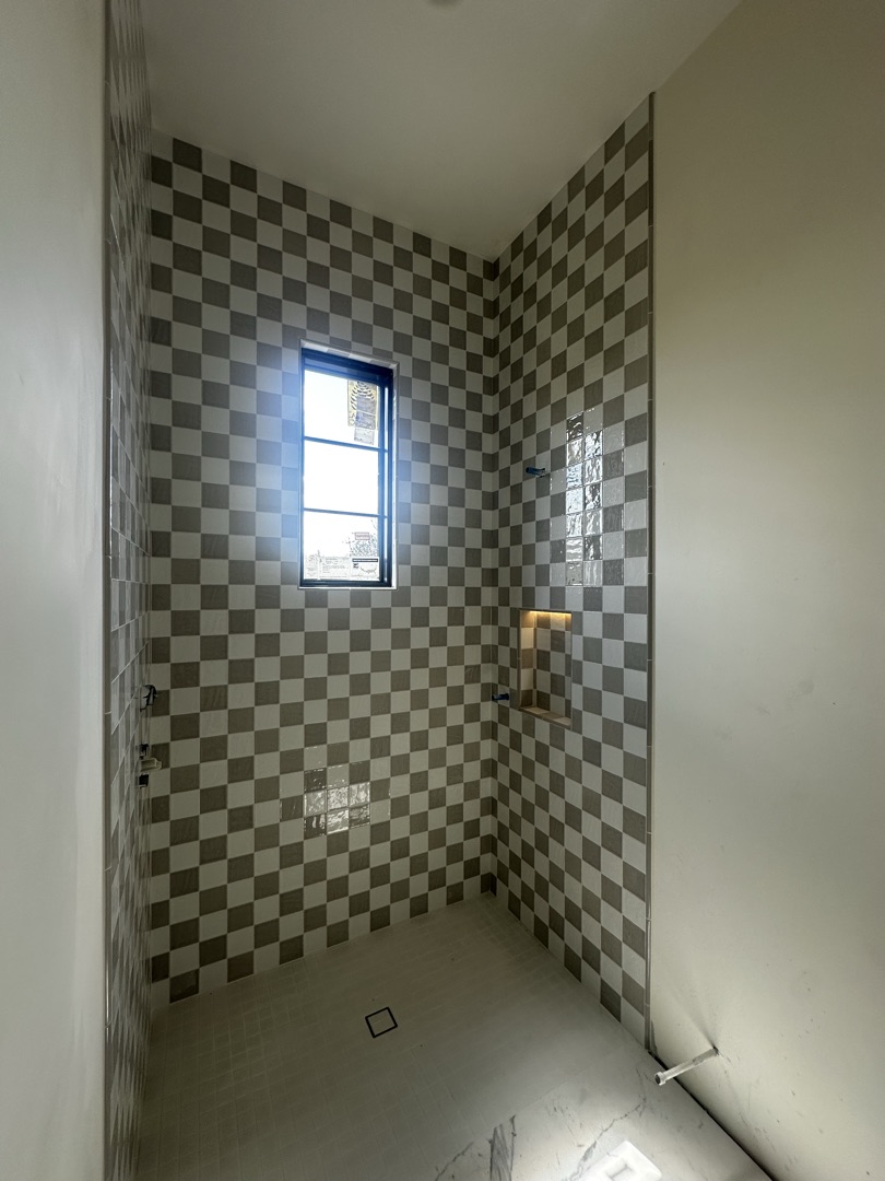 Bold checkerboard tile shower with custom niche by KV Tileworks, Central Florida