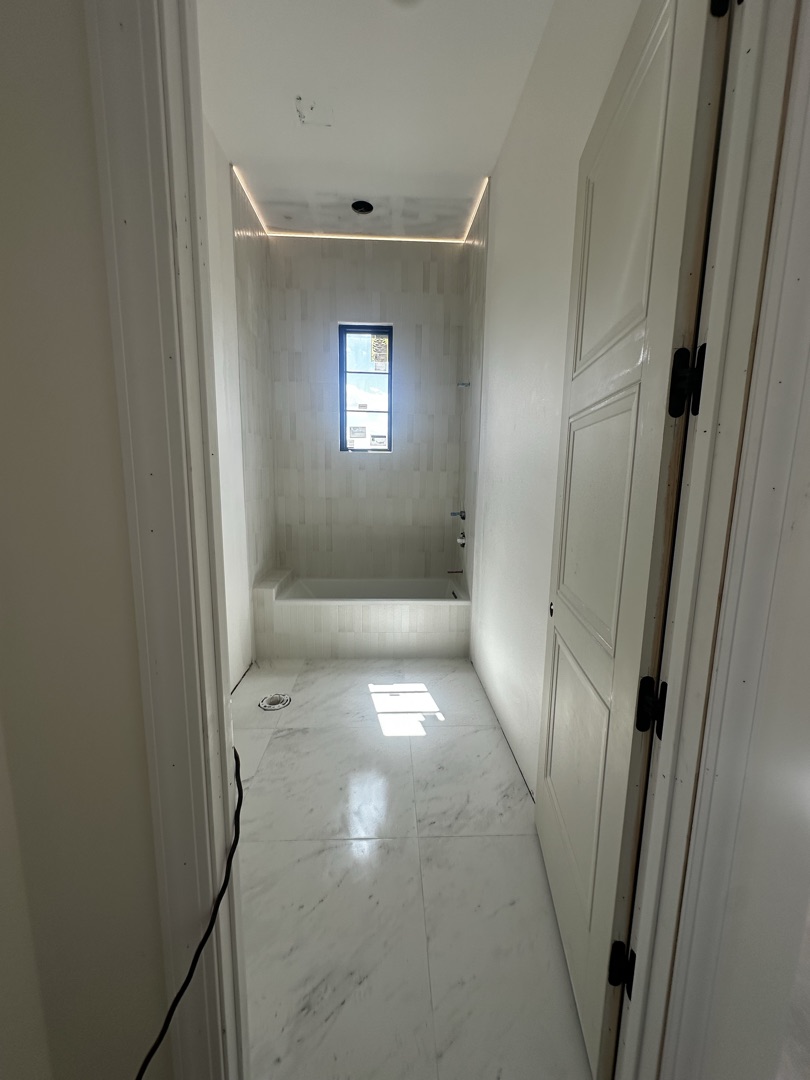 New construction master bath with marble floor and LED cove lighting by KV Tileworks